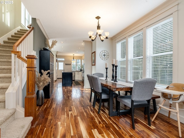 dining area with crown molding, dark wood-type flooring, and a chandelier