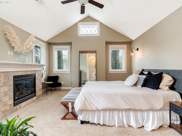 bedroom with ceiling fan, lofted ceiling, carpet, and a tile fireplace