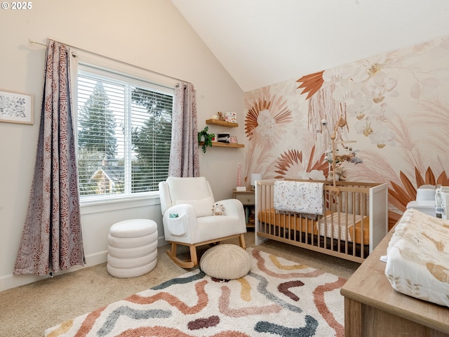 bedroom featuring vaulted ceiling, a nursery area, and carpet flooring