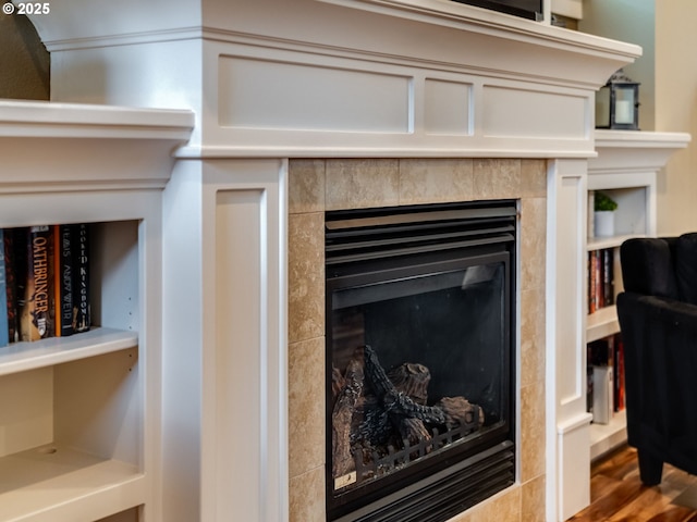 room details featuring hardwood / wood-style flooring and a tile fireplace