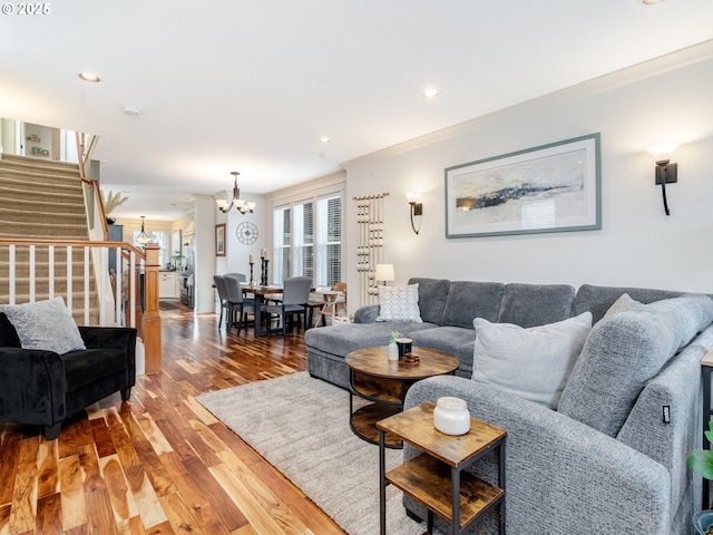 living room with ornamental molding, hardwood / wood-style floors, and a notable chandelier