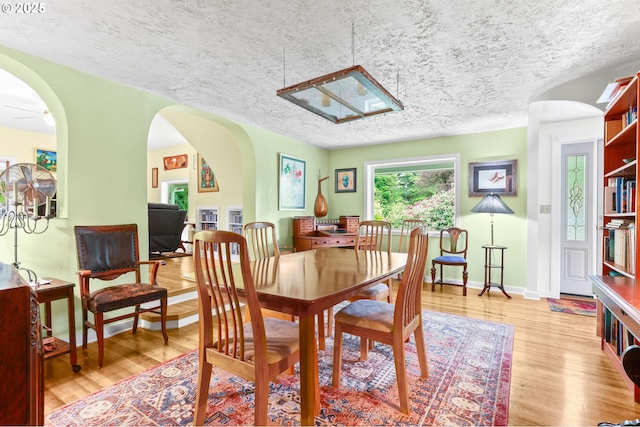 26011 S Morgan Rd, Estacada, OR 97023 - dining room featuring wood finished floors, a textured ceiling, arched walkways, and baseboards