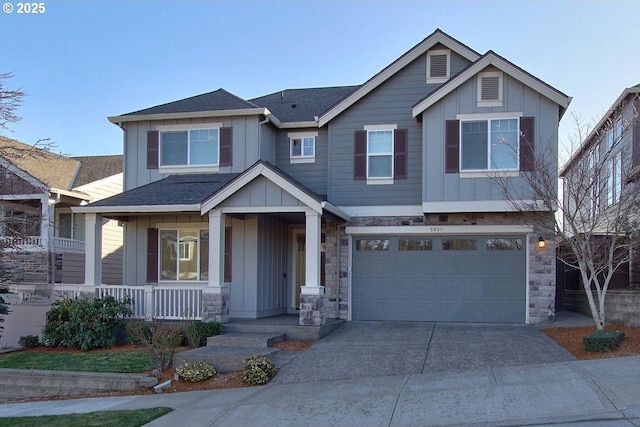 craftsman inspired home with board and batten siding, covered porch, driveway, and stone siding