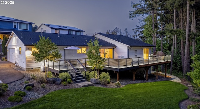 back of property with a yard, a deck, and stairway
