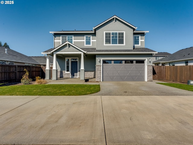 craftsman house with stone siding, concrete driveway, and fence