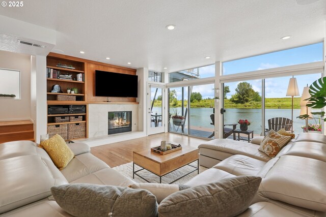 14569 NW Larson Rd Unit 13, Portland, OR 97231 - living room featuring wood finished floors, a fireplace, built in shelves, recessed lighting, and floor to ceiling windows