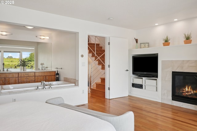 14569 NW Larson Rd Unit 13, Portland, OR 97231 - bedroom featuring wood finished floors, a tiled fireplace, and recessed lighting
