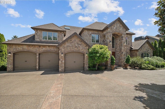2650 Lorinda Ln, West Linn, OR 97068 - french country style house featuring stone siding, driveway, a tiled roof, and an attached garage