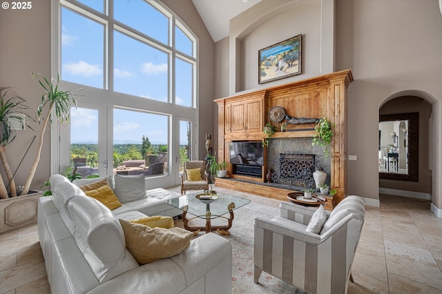 2650 Lorinda Ln, West Linn, OR 97068 - living area featuring high vaulted ceiling, a glass covered fireplace, healthy amount of natural light, arched walkways, and baseboards