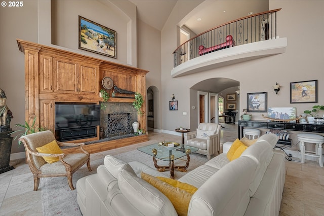 2650 Lorinda Ln, West Linn, OR 97068 - living room featuring arched walkways, a glass covered fireplace, a towering ceiling, and baseboards