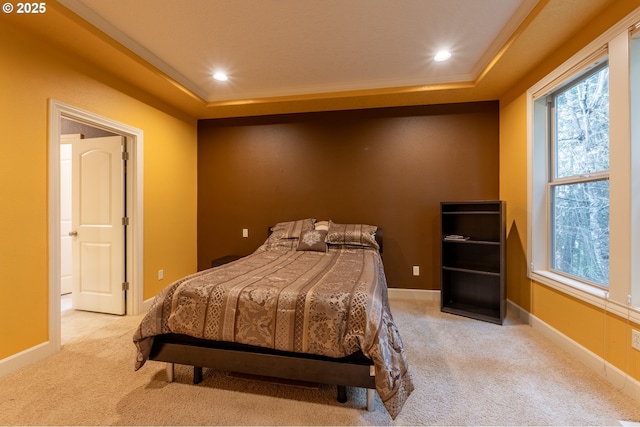 carpeted bedroom with a raised ceiling, crown molding, and recessed lighting