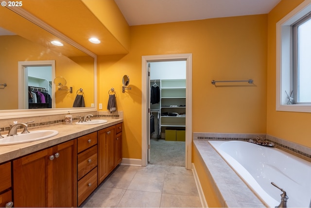 bathroom with a sink, tile patterned floors, double vanity, and a garden tub