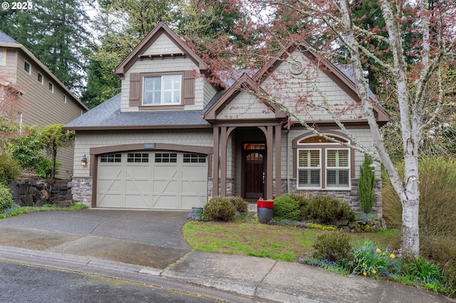 view of front of home with a shingled roof, stone siding, a garage, and driveway