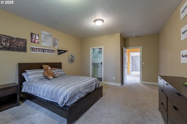 bedroom featuring baseboards, a walk in closet, a textured ceiling, and light colored carpet