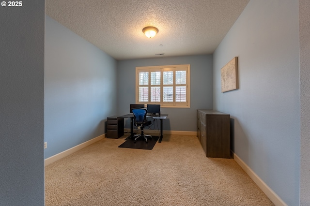 carpeted home office with a textured ceiling and baseboards