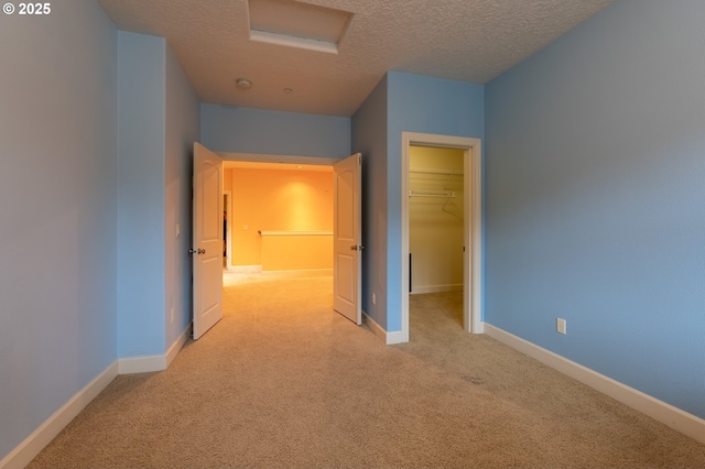 hall with a textured ceiling, baseboards, and carpet