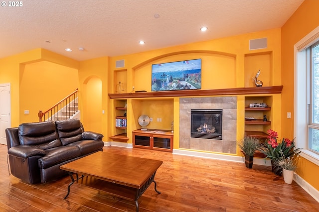 living area with wood-type flooring, visible vents, and built in features
