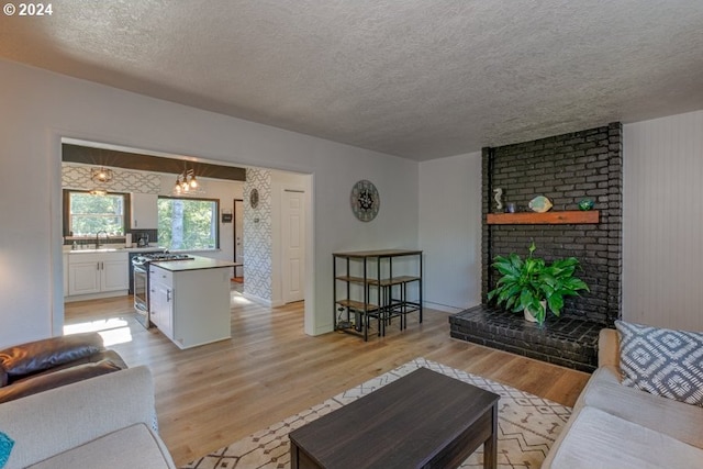 10391041 NE Grant St, Newport, OR 97365 - living room with light wood-type flooring, a textured ceiling, and a fireplace