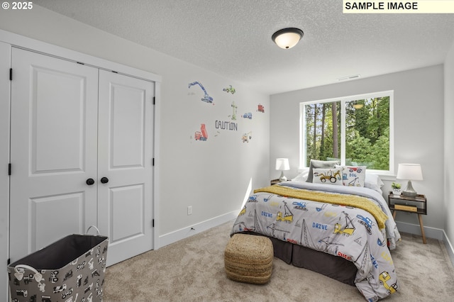 bedroom with a textured ceiling, visible vents, carpet floors, and baseboards