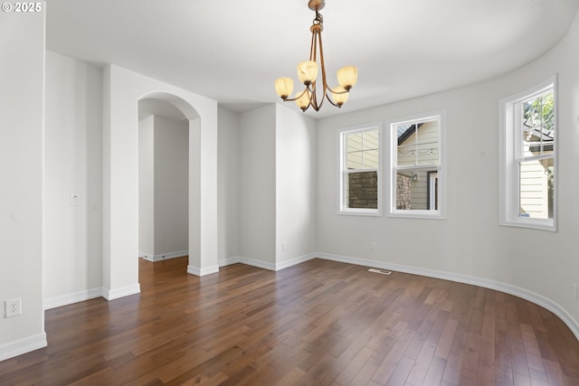 3504 NE Garfield St, Camas, WA 98607 - unfurnished room with a chandelier, healthy amount of natural light, arched walkways, and dark wood finished floors