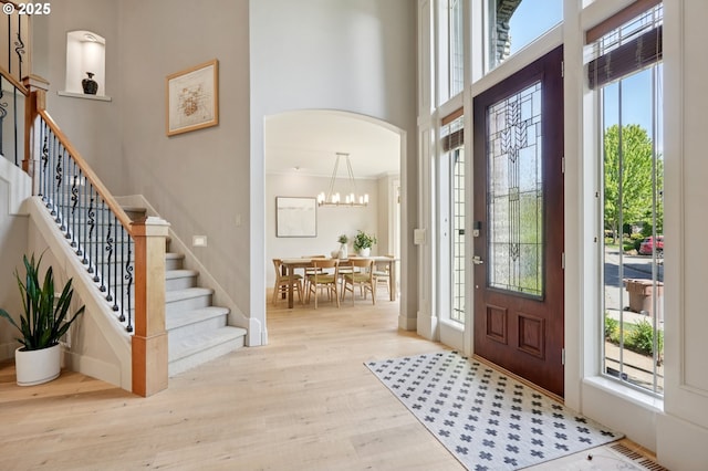 915 NE 36th Ave, Camas, WA 98607 - entrance foyer featuring wood finished floors, a towering ceiling, stairs, a chandelier, and arched walkways