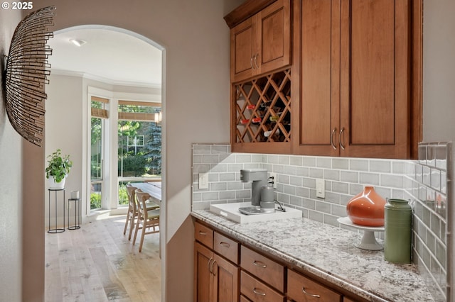 915 NE 36th Ave, Camas, WA 98607 - bar with arched walkways, crown molding, backsplash, and light wood-style flooring