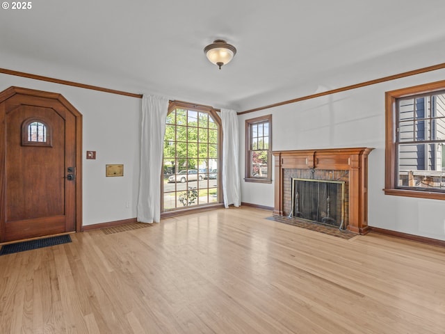 3310 NE 70th Ave, Portland, OR 97213 - unfurnished living room featuring light wood finished floors, baseboards, a brick fireplace, healthy amount of natural light, and ornamental molding