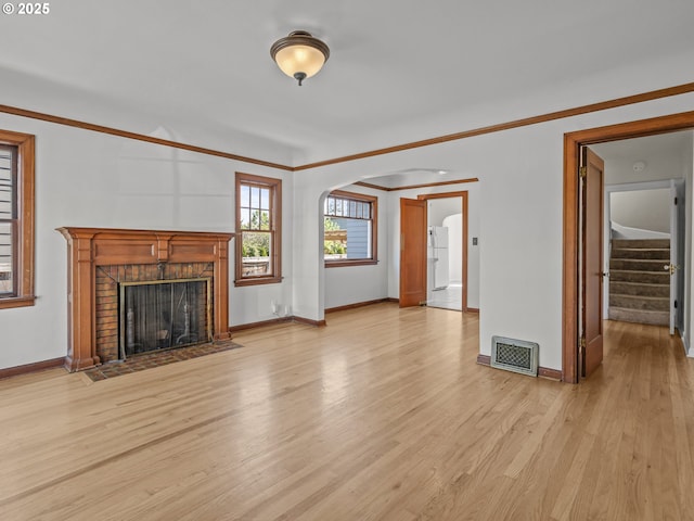 3310 NE 70th Ave, Portland, OR 97213 - unfurnished living room featuring arched walkways, wood finished floors, baseboards, and crown molding
