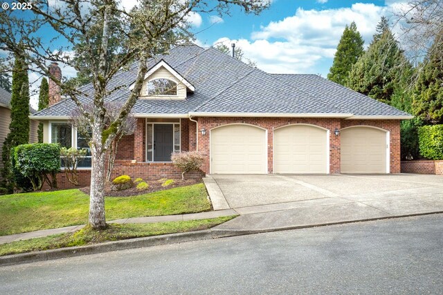 view of front of property featuring brick siding, a shingled roof, concrete driveway, an attached garage, and a front lawn