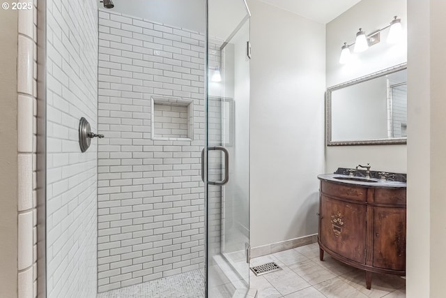 bathroom featuring baseboards, a shower stall, and vanity