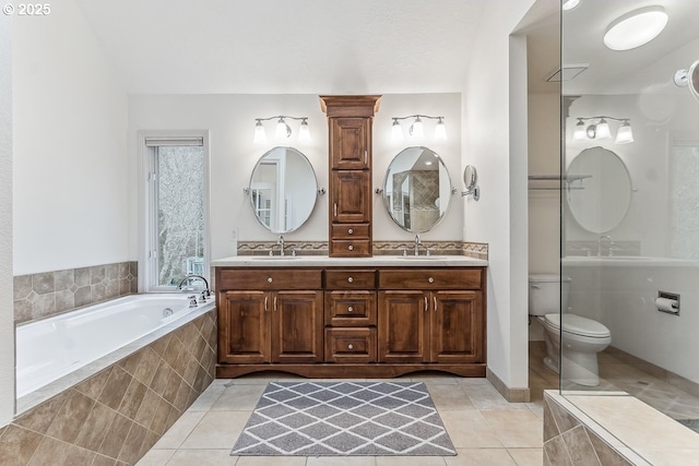 full bath with a bath, double vanity, a sink, and tile patterned floors