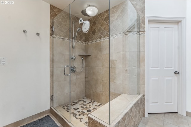 full bathroom with a stall shower, tile patterned flooring, and baseboards