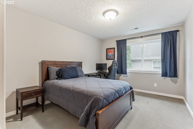 carpeted bedroom with baseboards, visible vents, and a textured ceiling