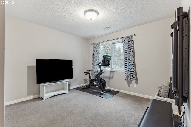 exercise room featuring a textured ceiling, carpet floors, visible vents, and baseboards