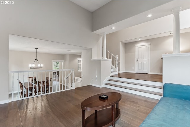 living area featuring recessed lighting, ornate columns, an inviting chandelier, wood finished floors, and baseboards