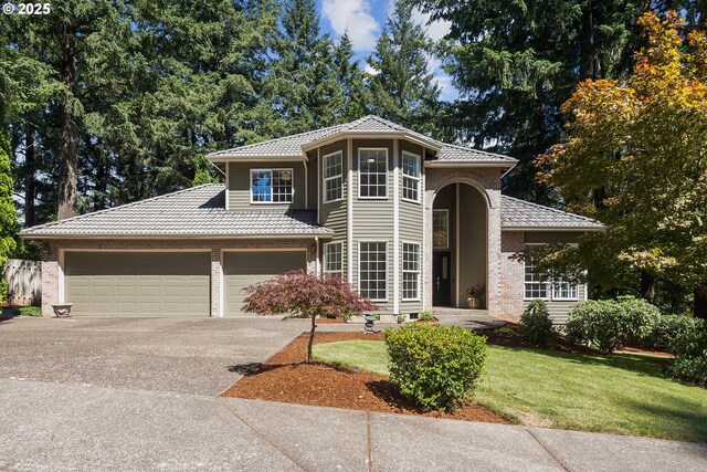 view of front of home with a garage and a front lawn