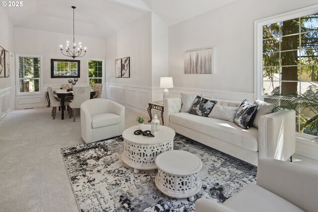 carpeted living room with an inviting chandelier and vaulted ceiling