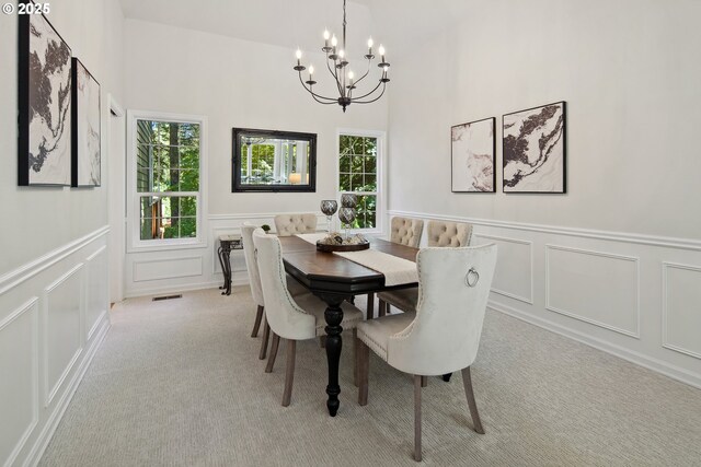 dining space with a notable chandelier and light colored carpet