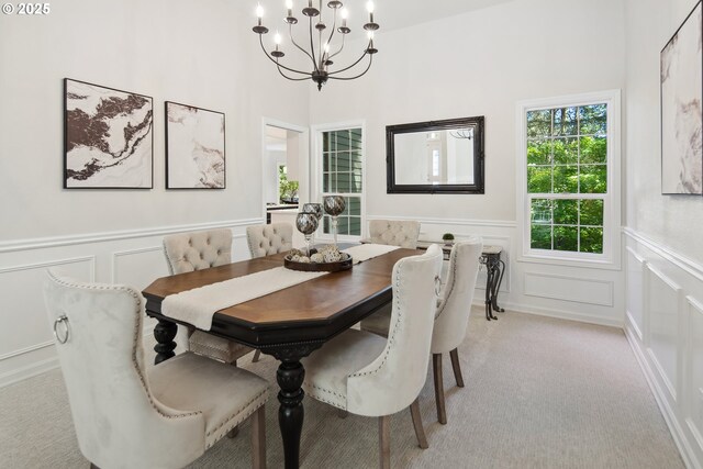 dining area featuring an inviting chandelier and light carpet