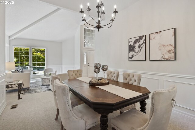 dining room featuring light carpet, vaulted ceiling, and a notable chandelier