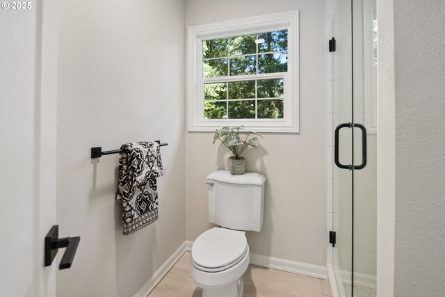 bathroom with toilet and a shower with door