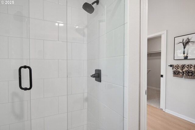 bathroom with an enclosed shower and wood-type flooring