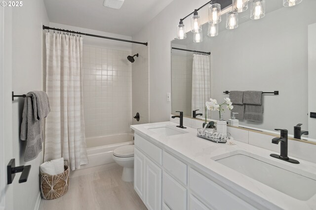 full bathroom with toilet, wood-type flooring, shower / tub combo with curtain, and vanity