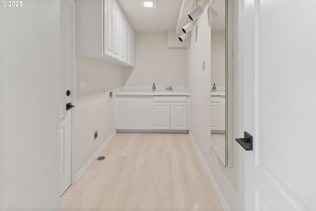 laundry area featuring hookup for a washing machine, cabinets, light wood-type flooring, and sink