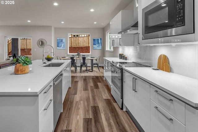 16779 SE Shimmering Leaf St, Happy Valley, OR 97086 - kitchen featuring modern cabinets, wall chimney range hood, white cabinetry, a sink, and appliances with stainless steel finishes