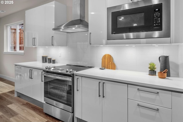 16779 SE Shimmering Leaf St, Happy Valley, OR 97086 - kitchen with stainless steel electric range oven, wall chimney exhaust hood, built in microwave, and modern cabinets