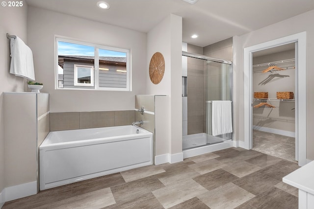 16779 SE Shimmering Leaf St, Happy Valley, OR 97086 - bathroom with recessed lighting, baseboards, a shower stall, a spacious closet, and a garden tub