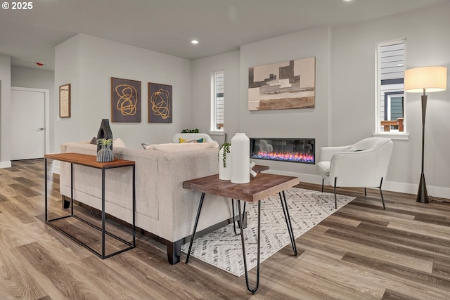 16779 SE Shimmering Leaf St, Happy Valley, OR 97086 - living area featuring a glass covered fireplace, baseboards, recessed lighting, and wood finished floors