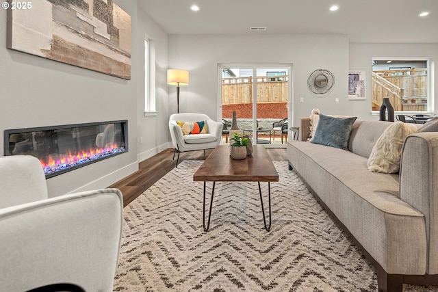 16779 SE Shimmering Leaf St, Happy Valley, OR 97086 - living room featuring visible vents, a glass covered fireplace, wood finished floors, baseboards, and recessed lighting
