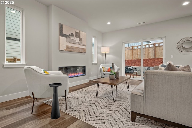 16779 SE Shimmering Leaf St, Happy Valley, OR 97086 - living area with recessed lighting, baseboards, a glass covered fireplace, and wood finished floors